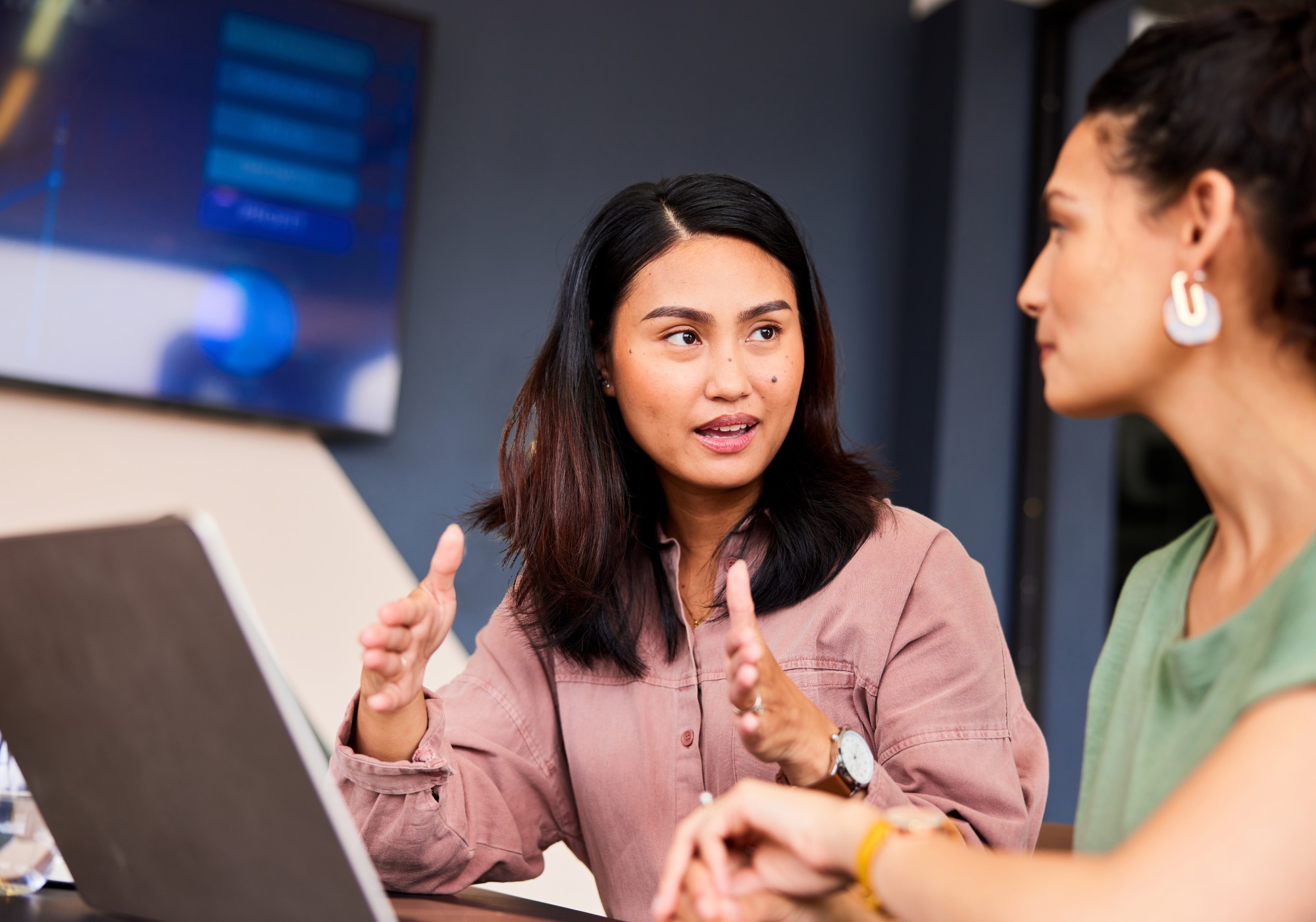 Two women discussing work at a desk