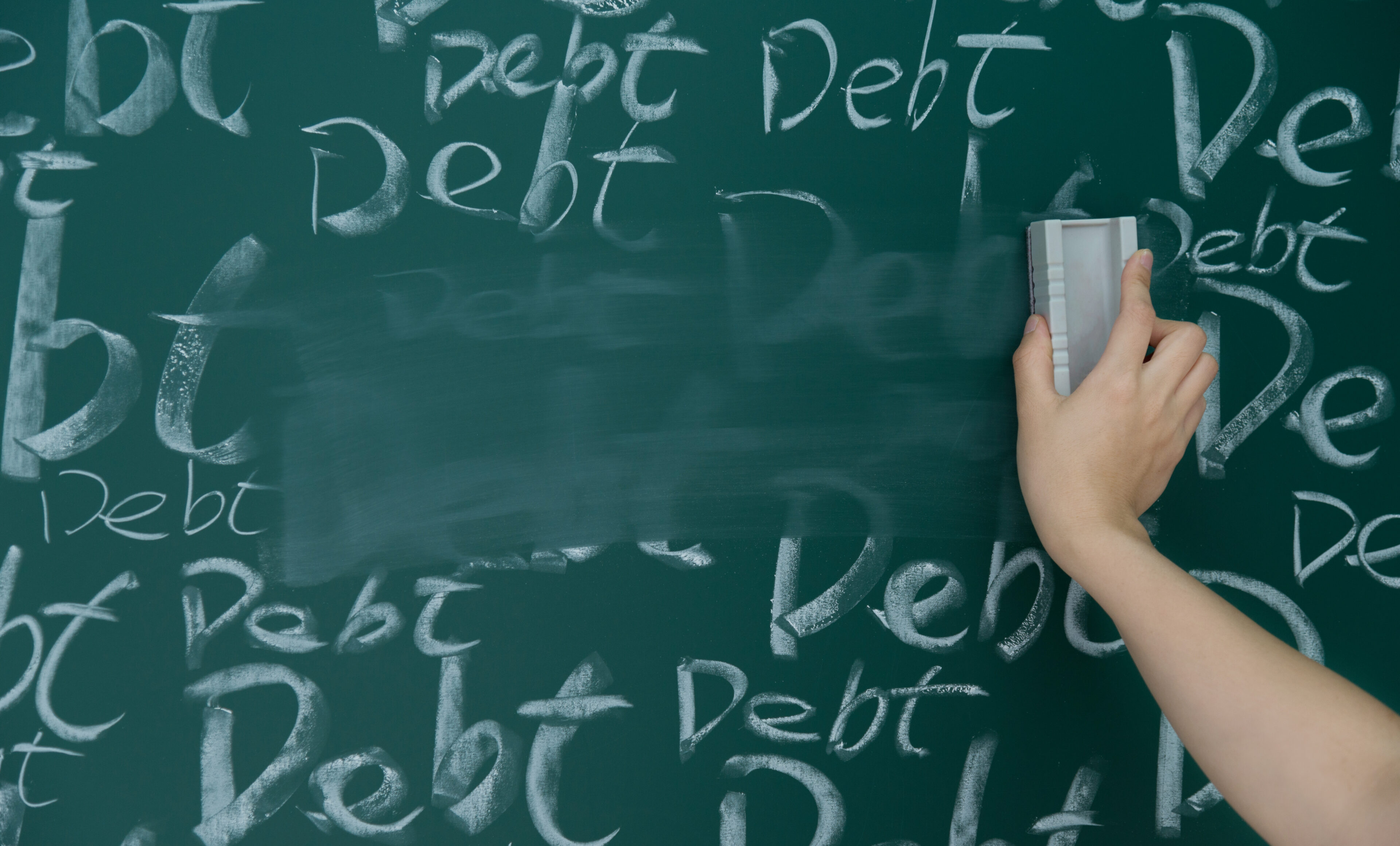 Wiping debt on a chalkboard.